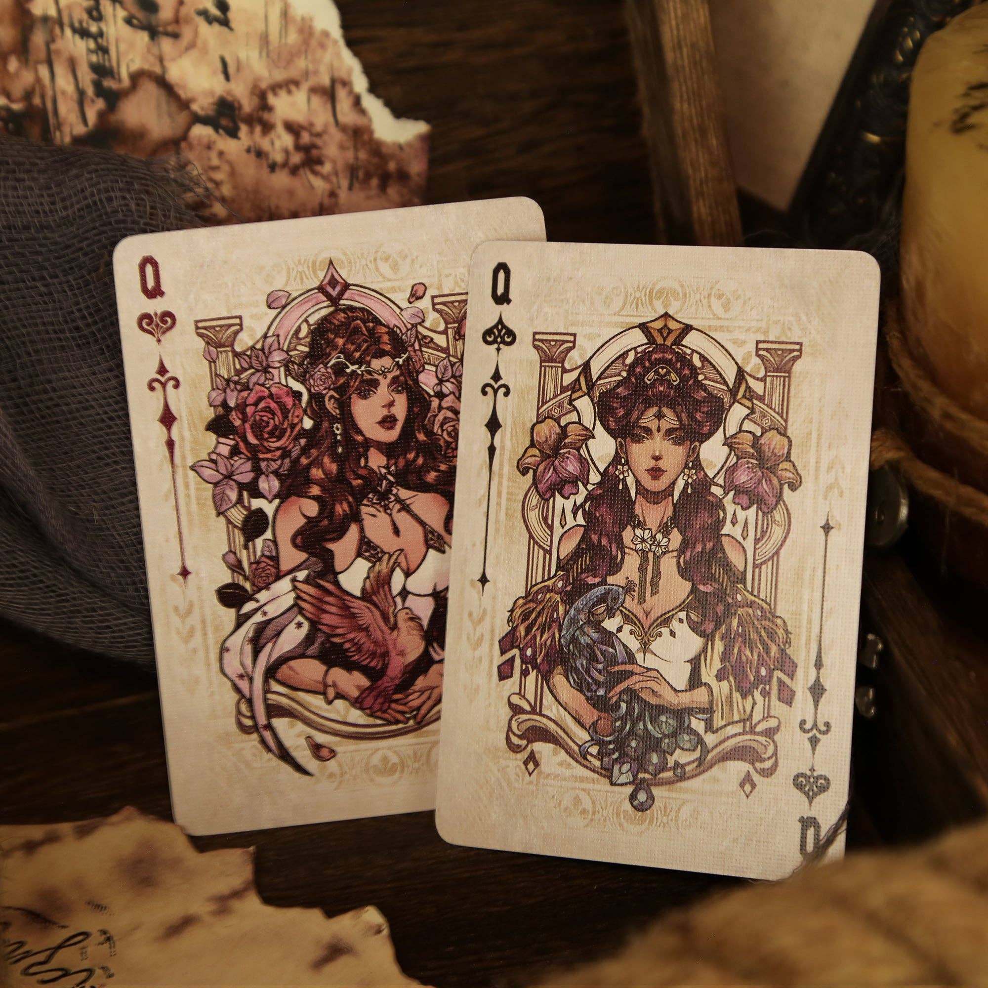 Two playing cards with decorative designs on a textured surface