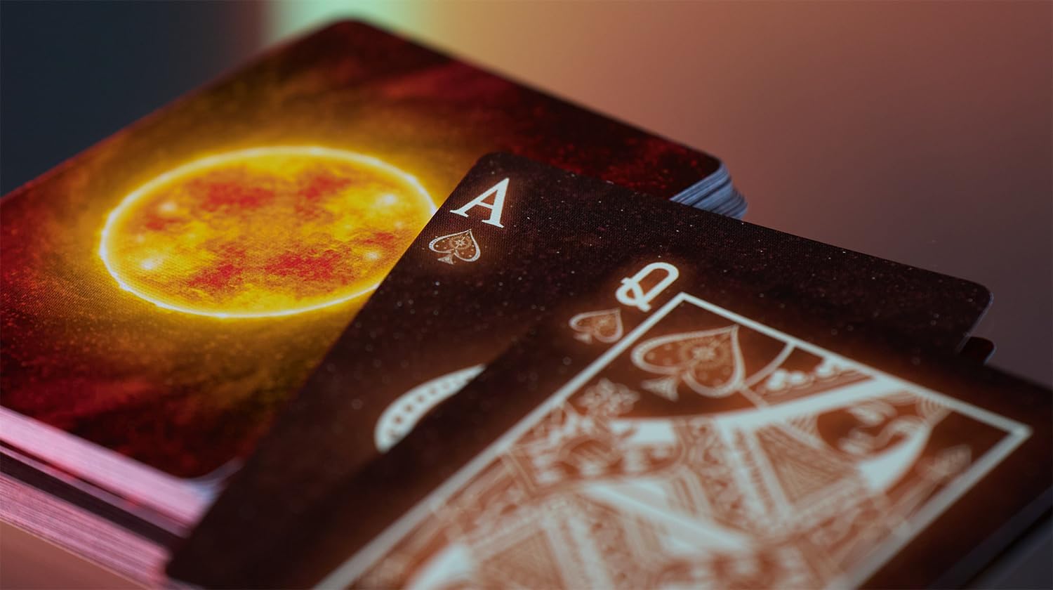 Close-up of playing cards with a prominent card featuring a bright yellow circle and another card with a detailed illustration.