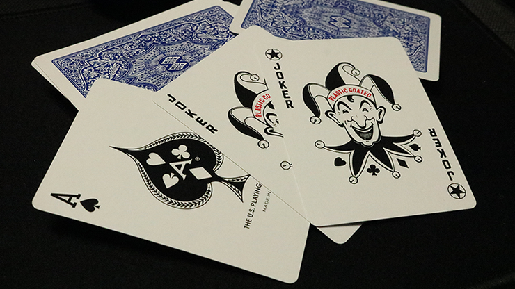 Playing cards with a joker and ace of spades on a dark background