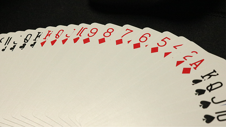 Playing cards fanned out on a white surface with a black background