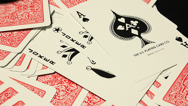 Close-up of playing cards with a prominent Ace of Spades card showing the brand logo.