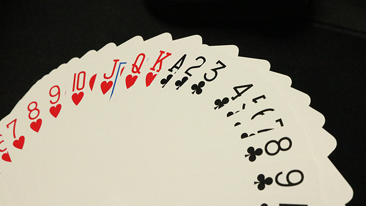 Fanned-out deck of playing cards with red and black text on a dark background