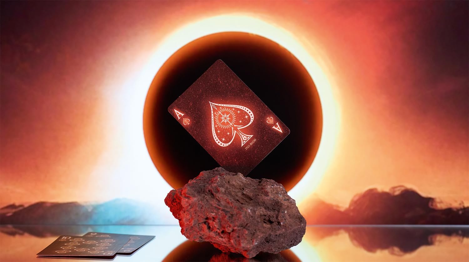Playing card with a red diamond symbol on a rock against a sunset sky