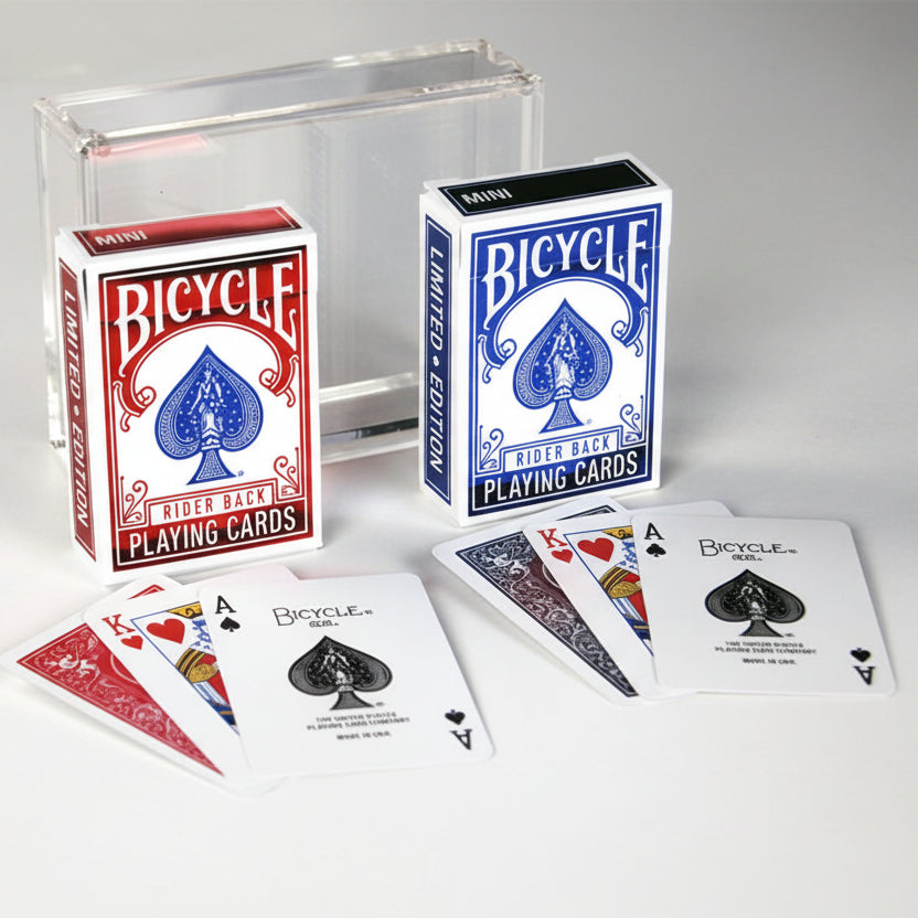 Acrylic Carat case holding red and blue Bicycle Rider Back mini decks with foil tuck boxes and spread cards in front.