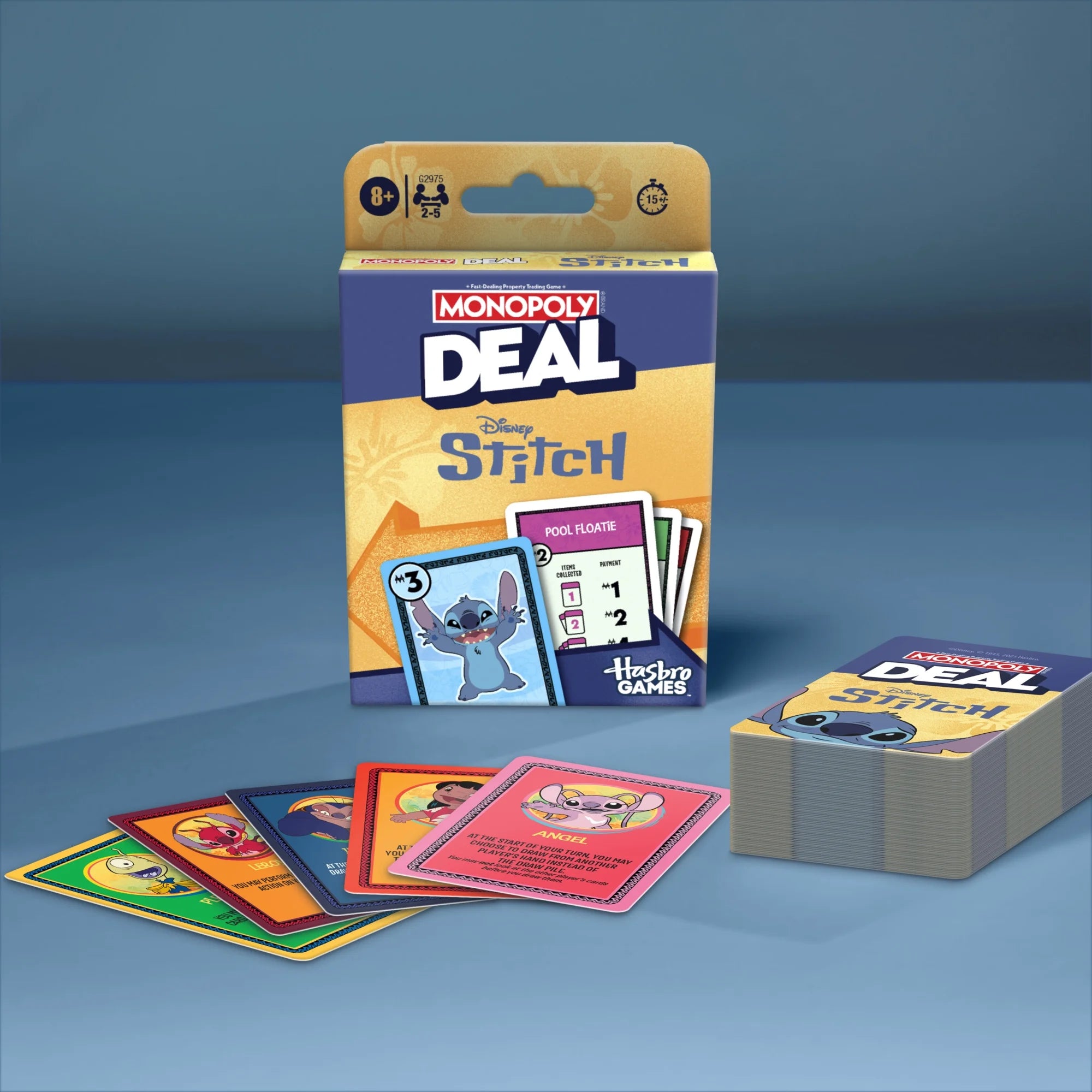 Monopoly Deal Disney Stitch board game packaging with several colorful cards fanned out in front and a stack of cards on a blue studio background.