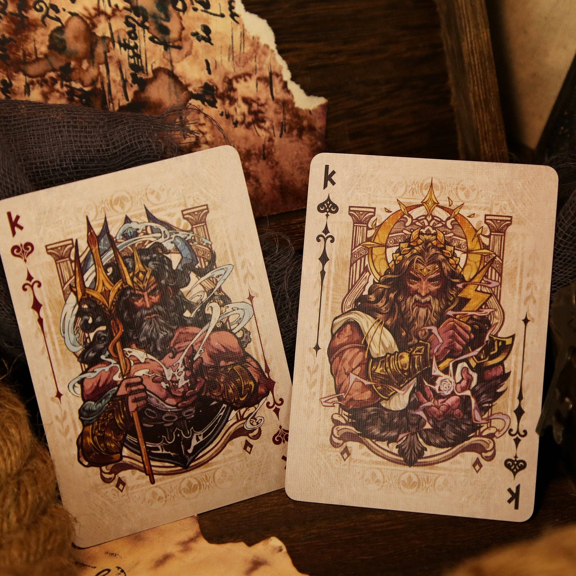 Two playing cards featuring kings with detailed artwork on a textured surface.
