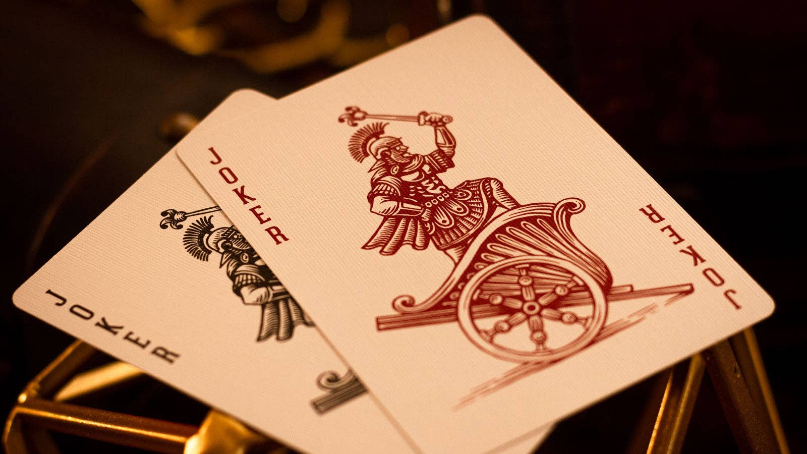 Two Centurio playing cards with a joker design on a dark background