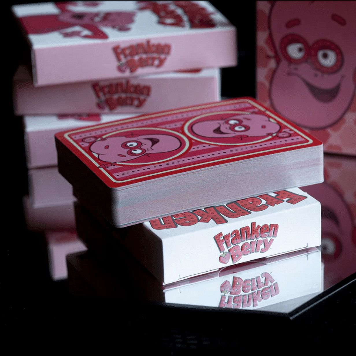 Stack of playing cards with 'Franken Berry' branding on a reflective surface.