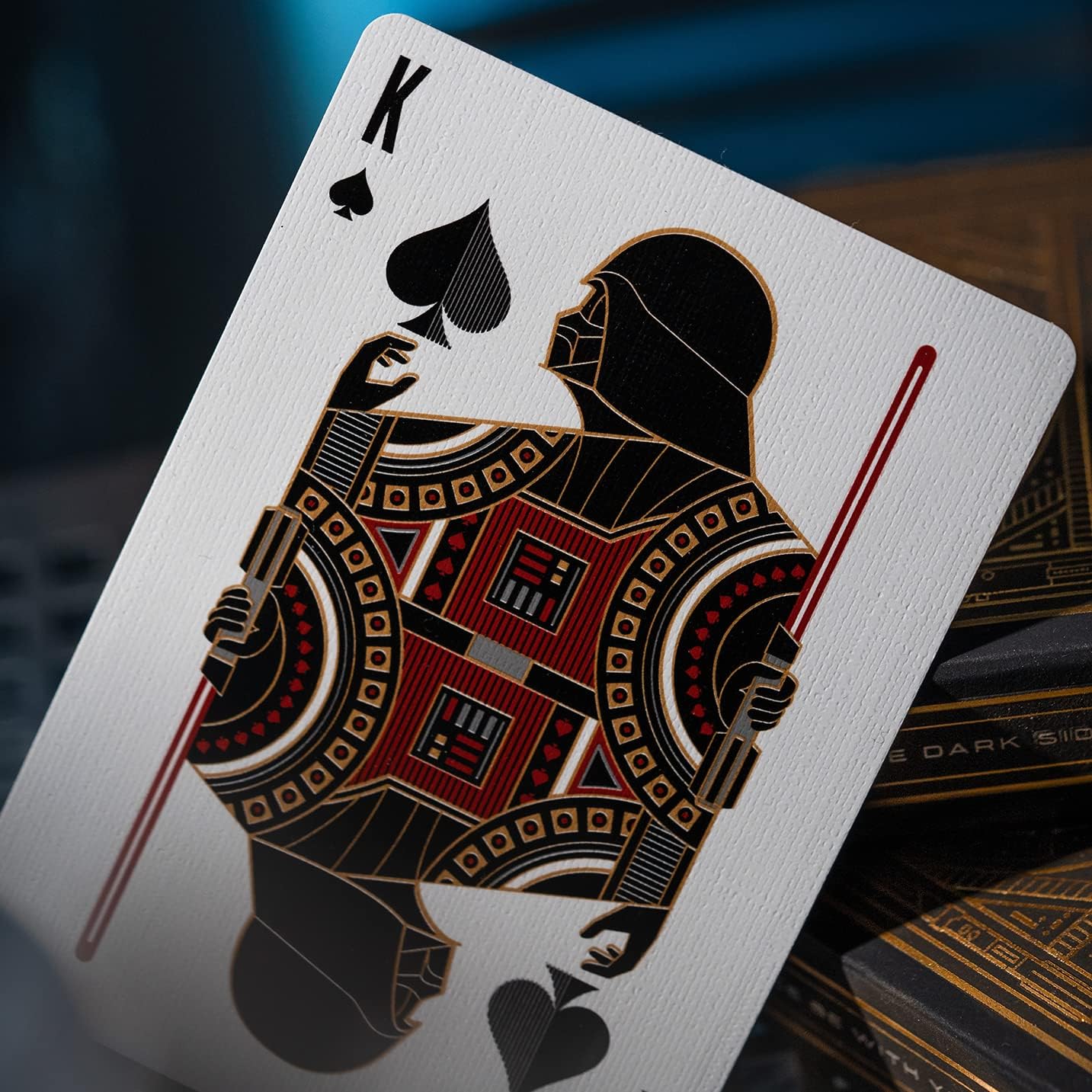 Playing card with a detailed design of a character holding a lightsaber, on a dark background.