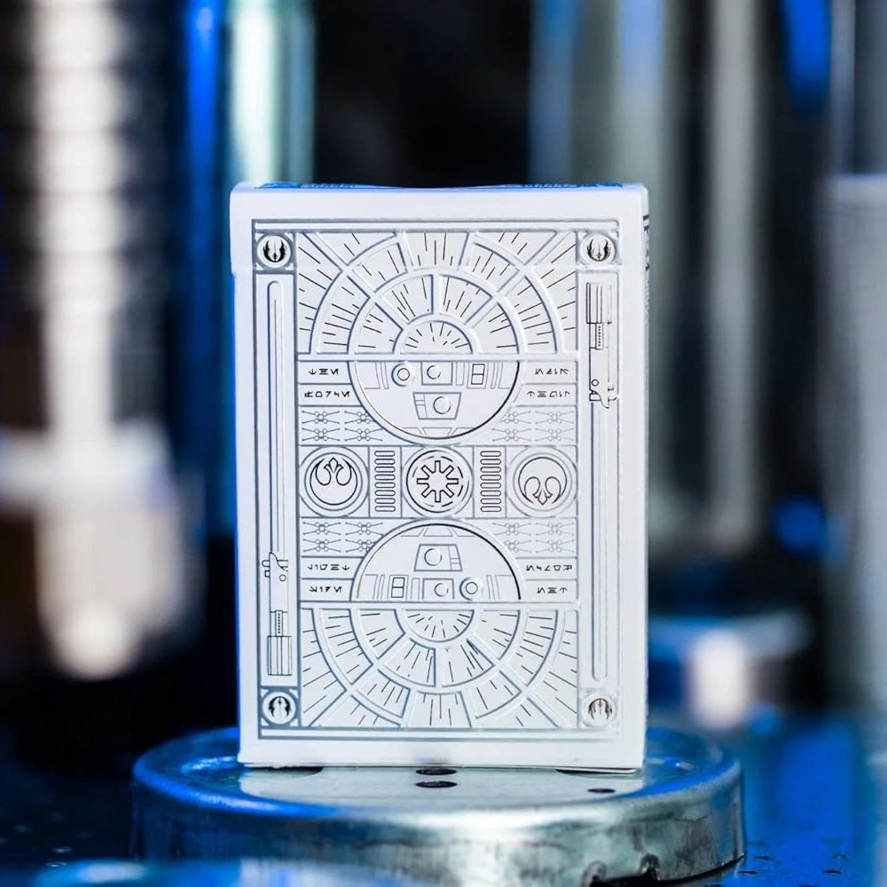 White playing card with black geometric design on a metallic stand against a blurred background