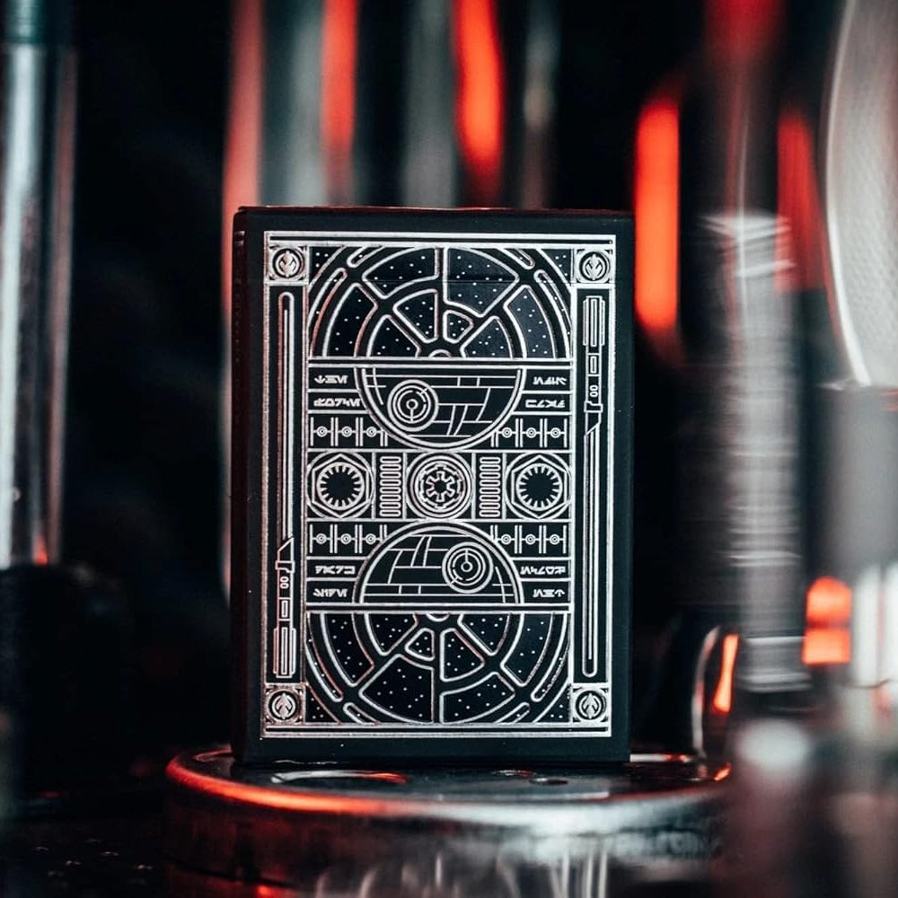 Black playing card with white geometric design on a dark background