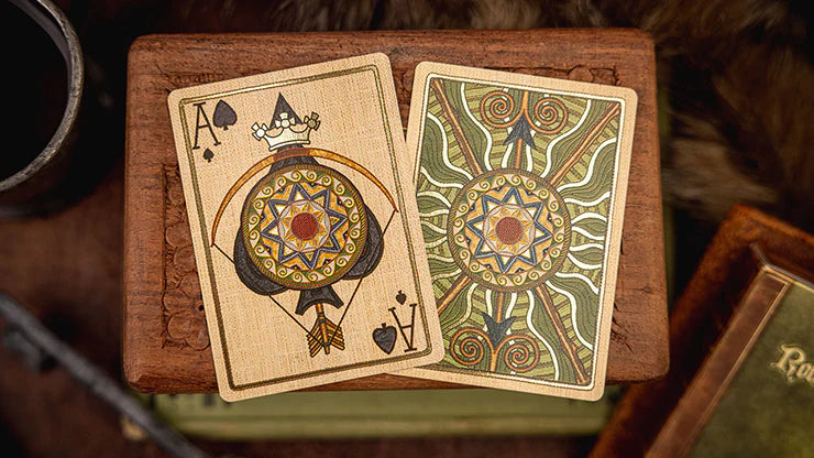 Two intricately designed playing cards on a wooden surface with a warm, rustic background.
