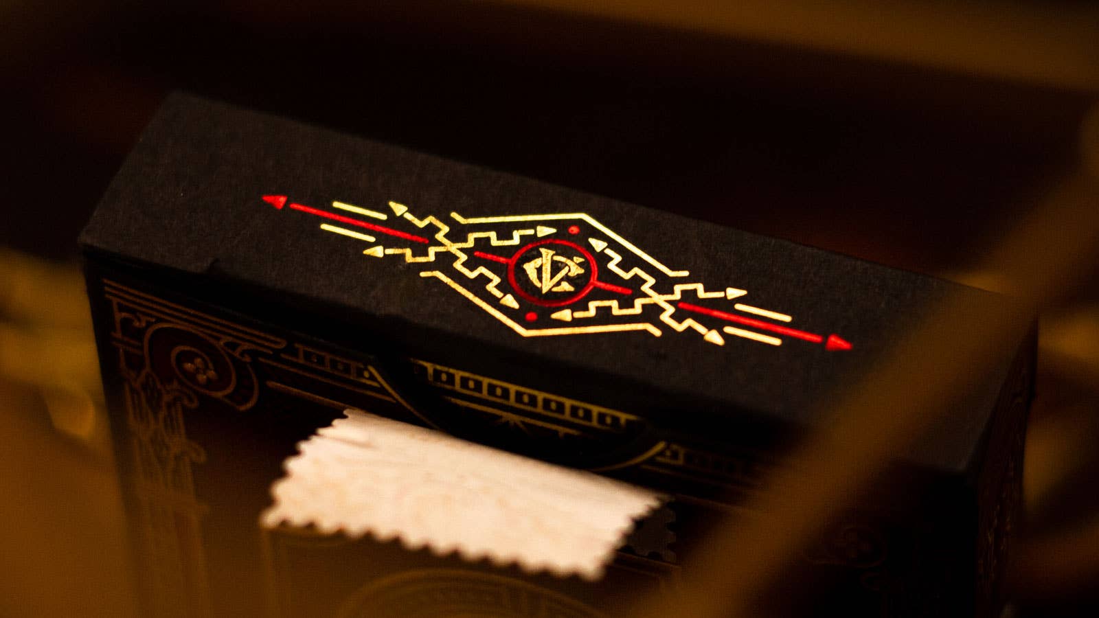 Close-up of a black Centurio box with a red and yellow emblem on a dark background