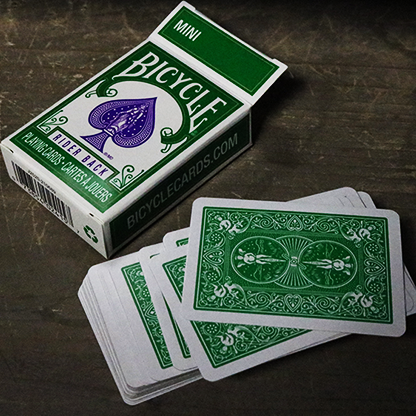 Green Bicycle Mini playing cards with a deck on a wooden surface