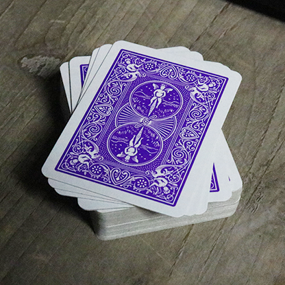 Stack of purple Bicycle Mini playing cards on a wooden surface