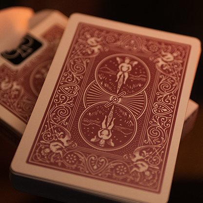 Close-up of a deck of Bicycle Metallic Ruby Playing Cards with intricate designs on a dark background