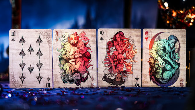 Four Keyhole Luxury Edition playing cards with artistic designs on a dark background