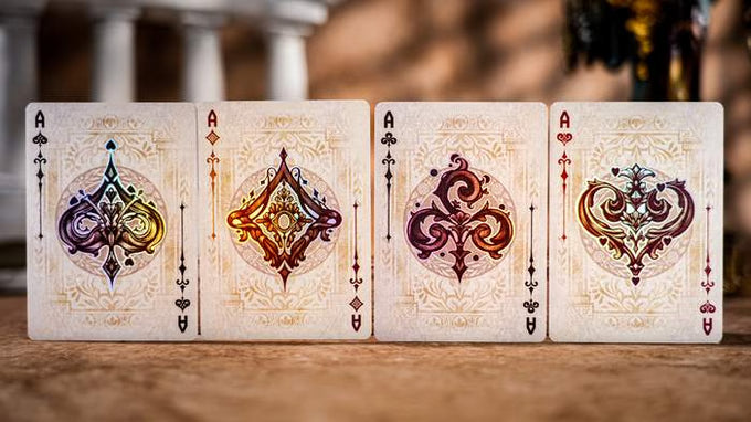 Four Keyhole Luxury Edition playing card aces with ornate designs on a wooden surface.
