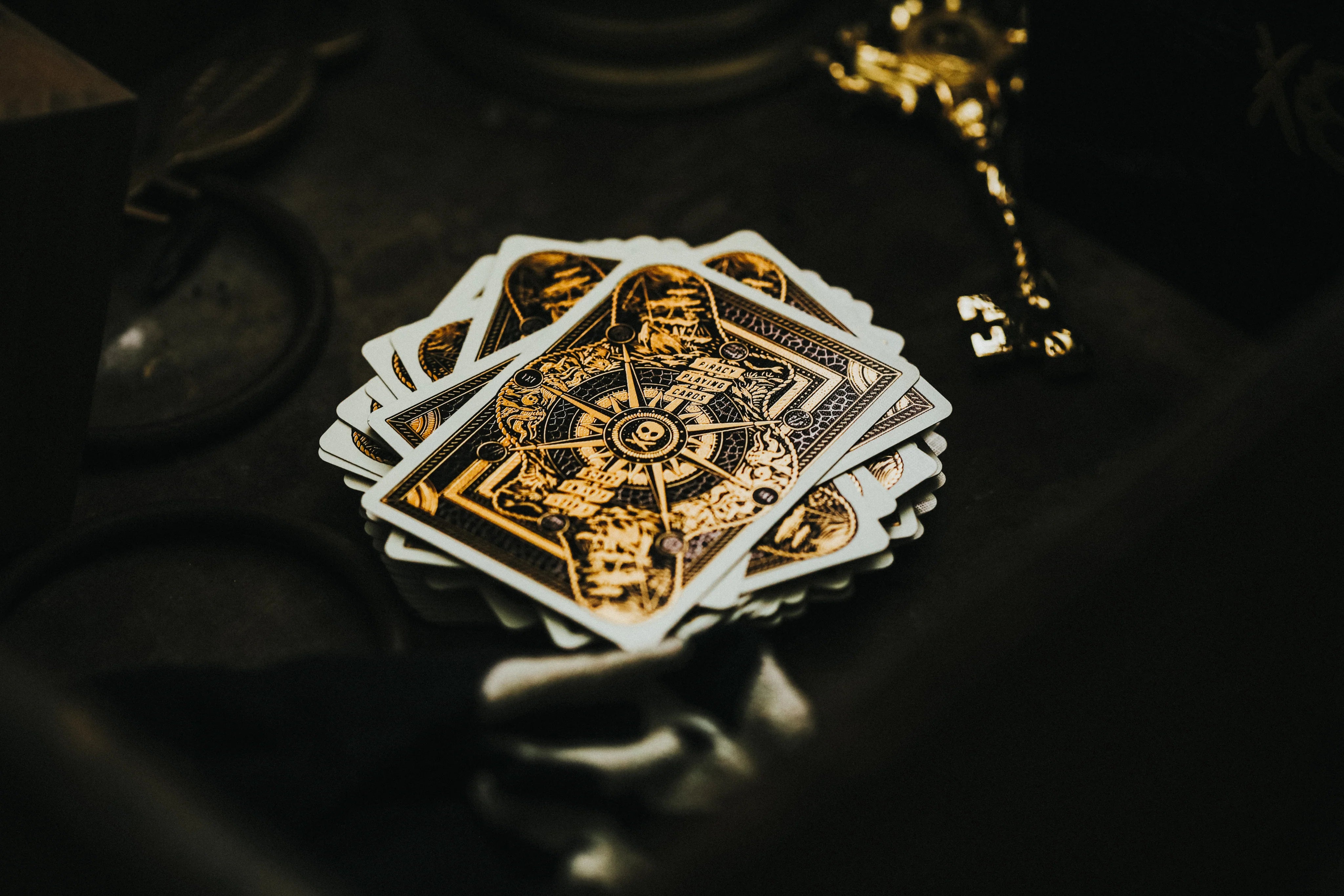 Stack of Piracy playing cards with intricate designs on a dark surface