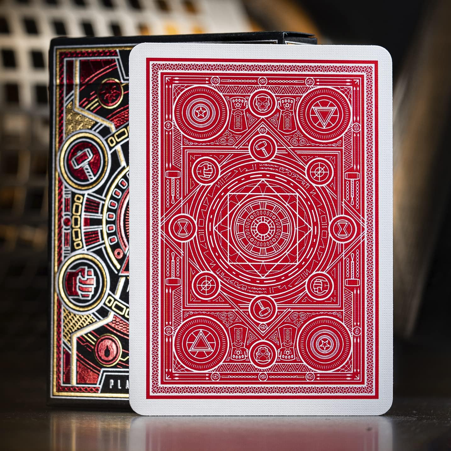 Two playing card decks with intricate designs on a blurred background