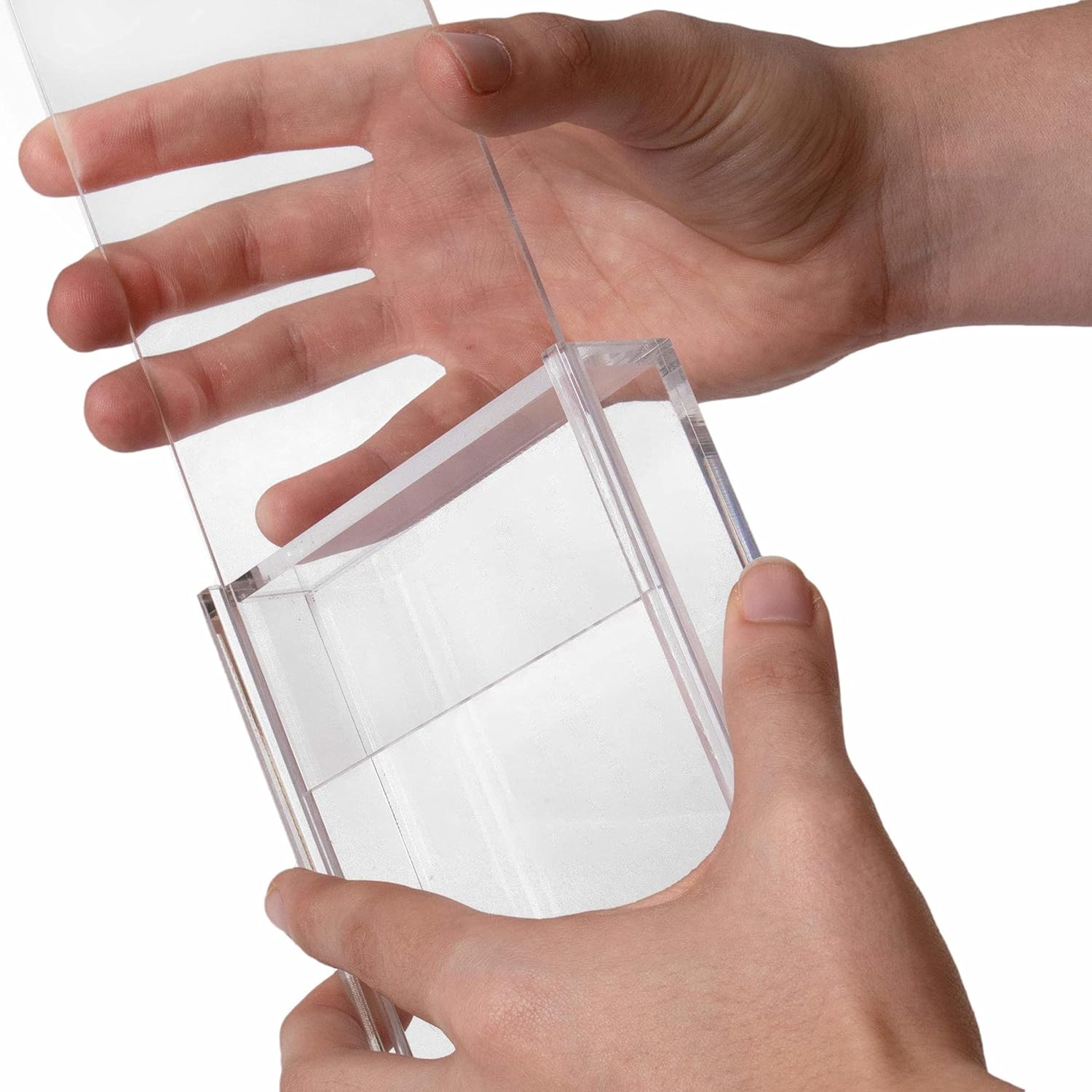 Clear plastic container held by a hand against a white background