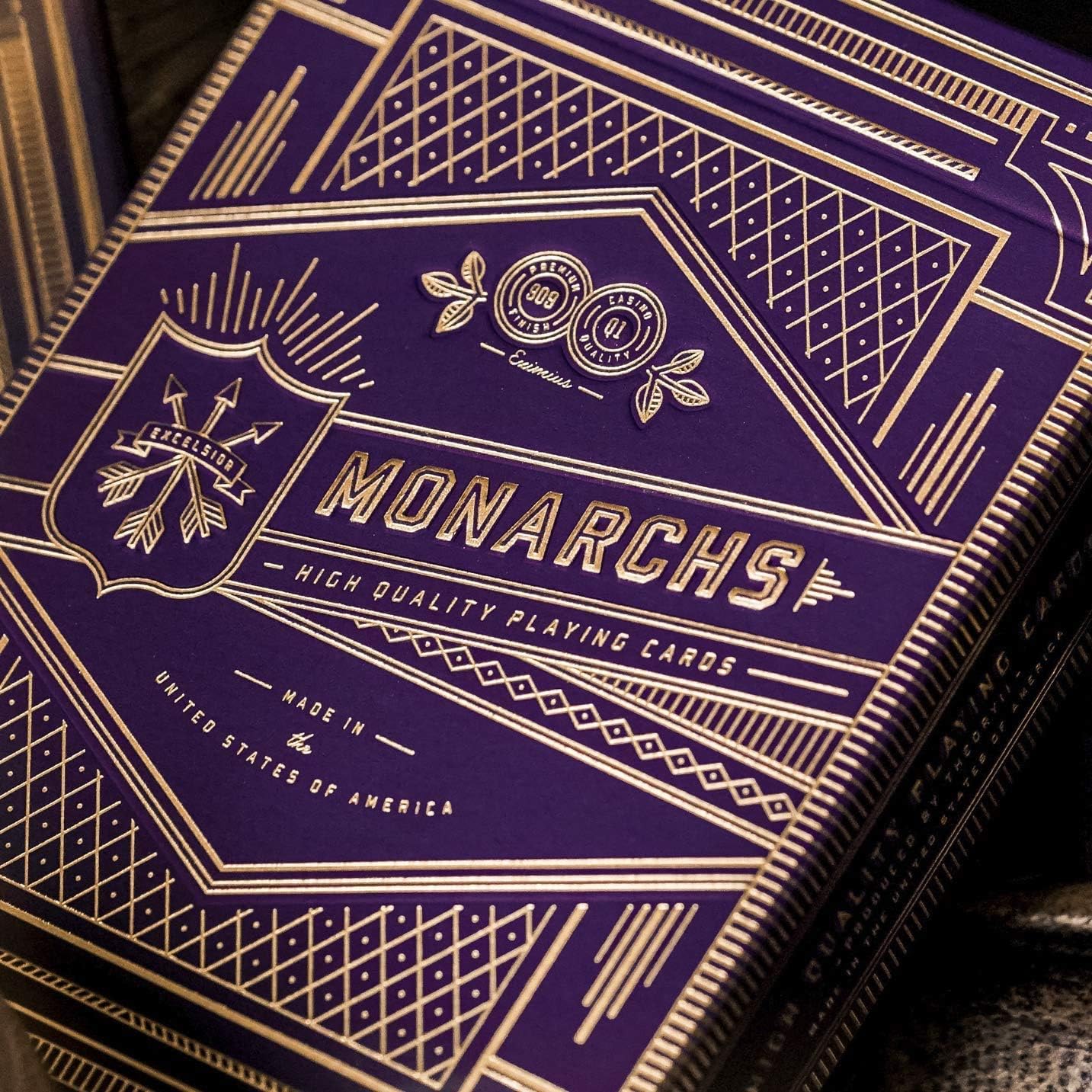 Close-up of a purple and gold Monarchs playing card box with intricate designs.