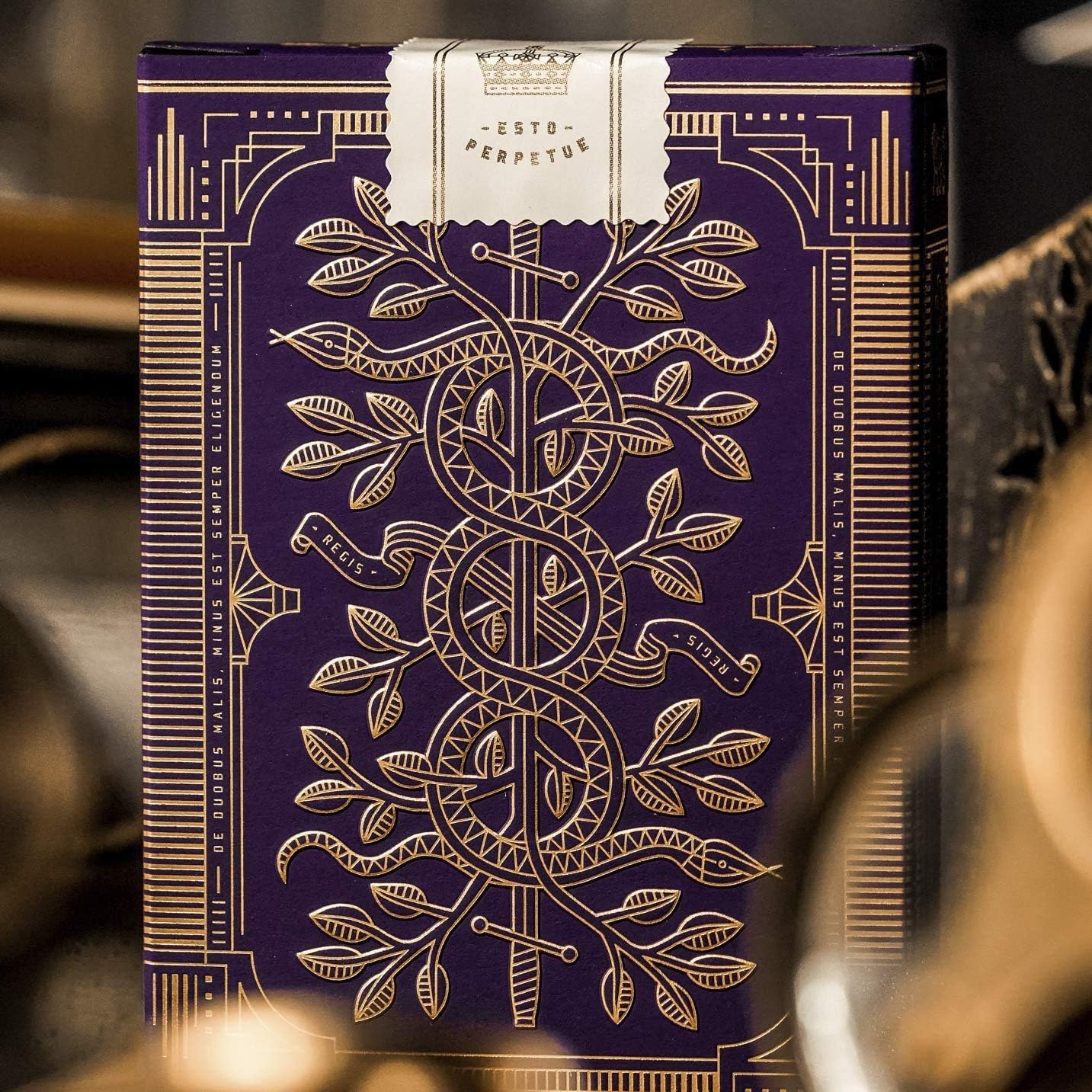 Decorative purple and gold Monarch packaging with intricate designs on a blurred background