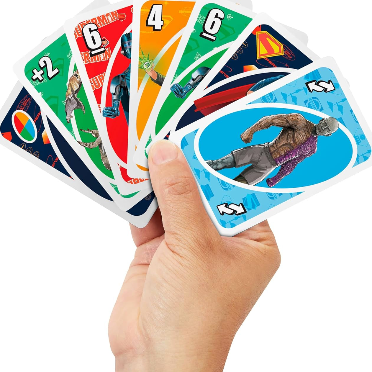 A hand holding a fan of UNO Superman card game