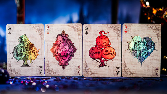 Four Keyhole Luxury Edition playing cards with colorful designs on a blurred background