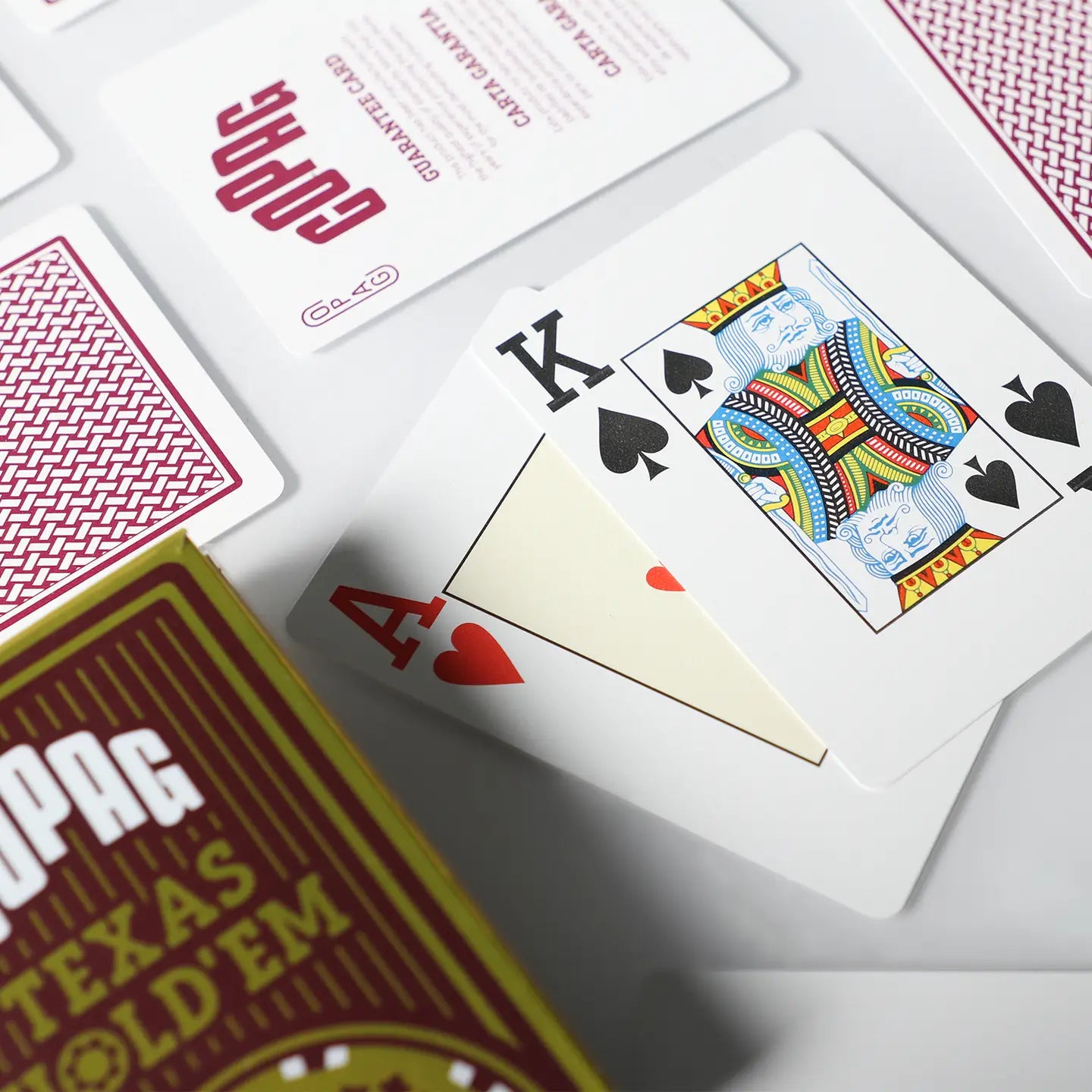 Playing cards with King of Spades and Ace of Hearts on a white surface