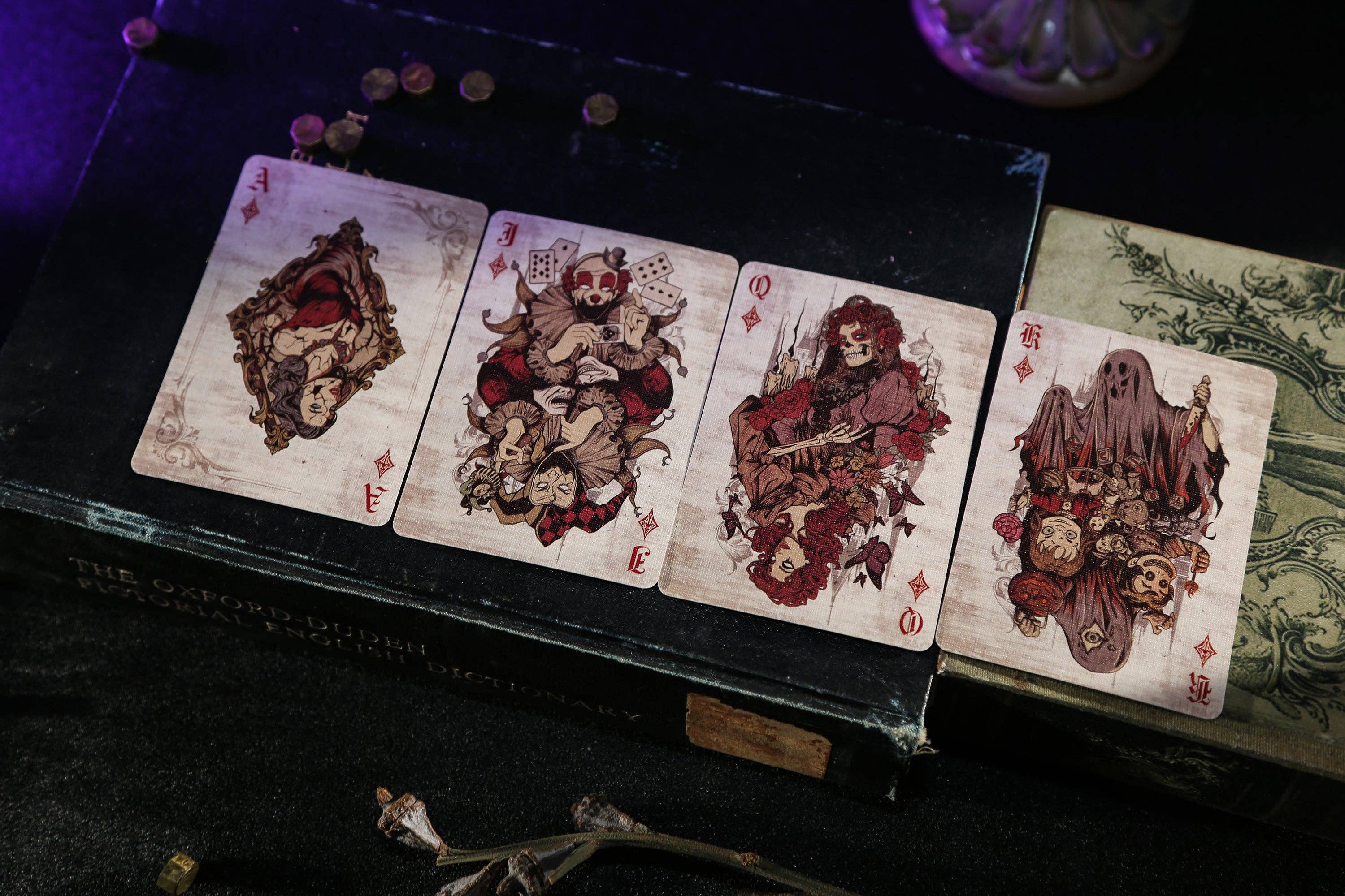 Set of cards with gothic illustrations on a dark surface.