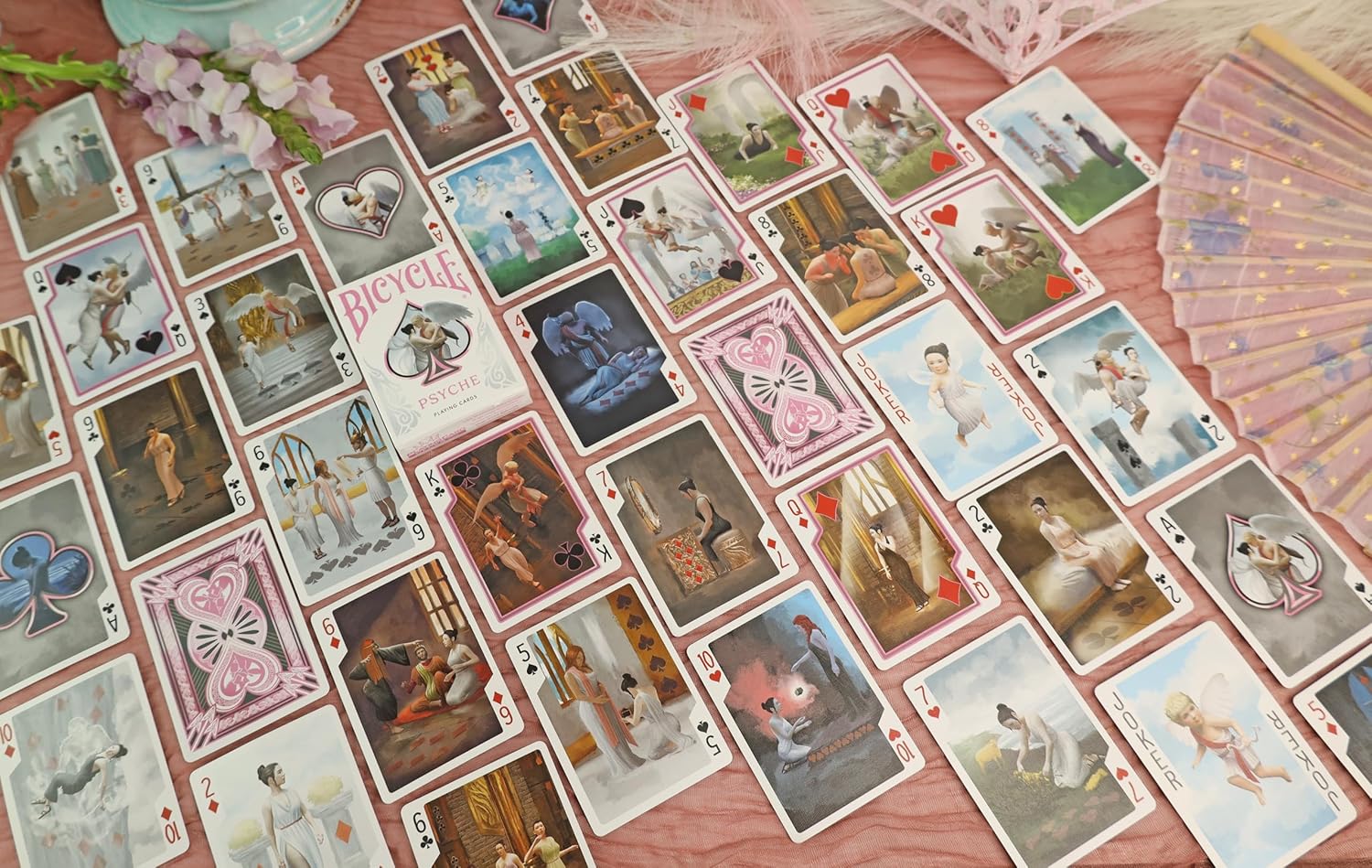 Collection of Psyche playing cards on a pink surface with decorative elements.