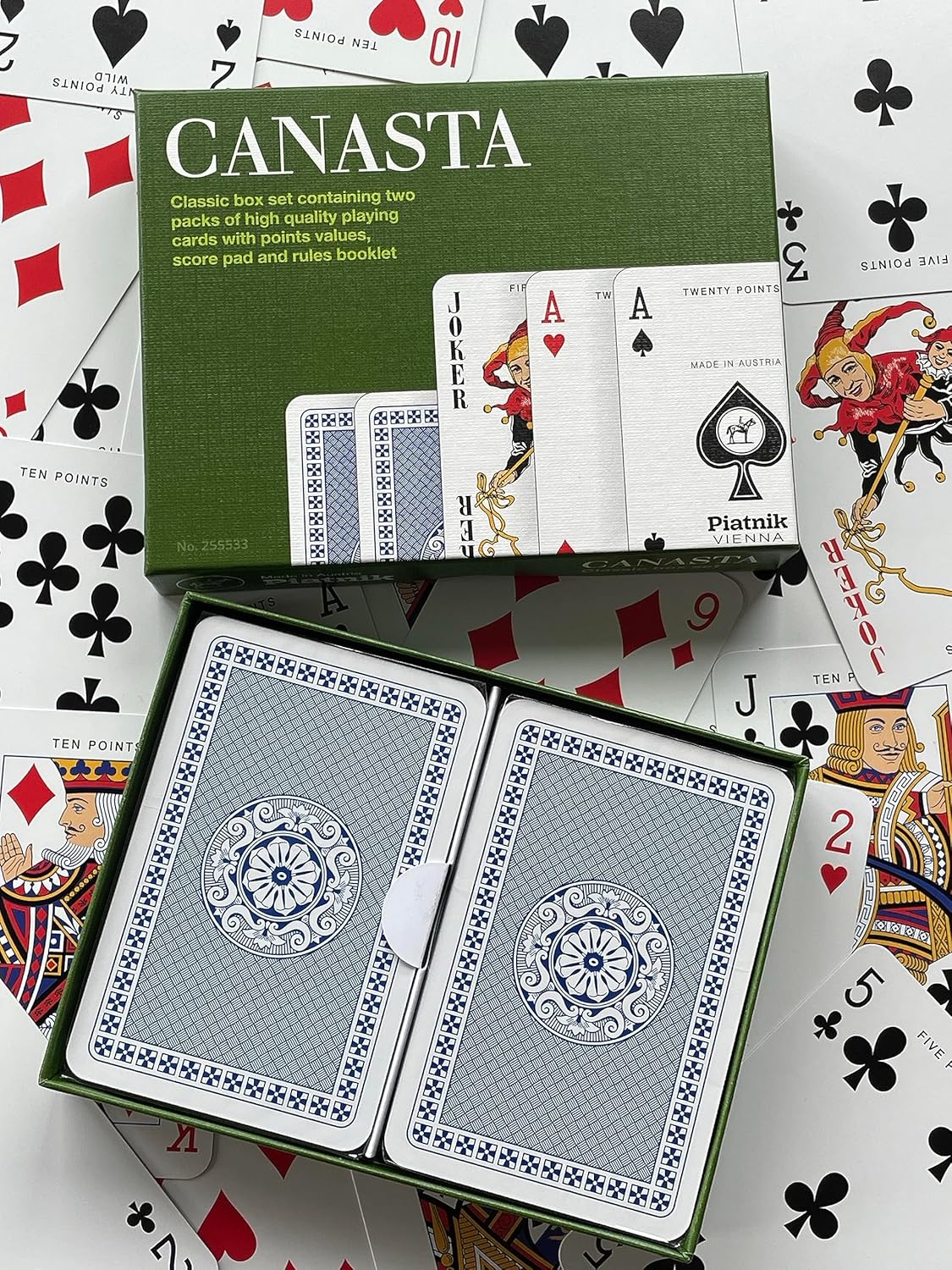 Canasta playing card set with green box on a background of playing cards
