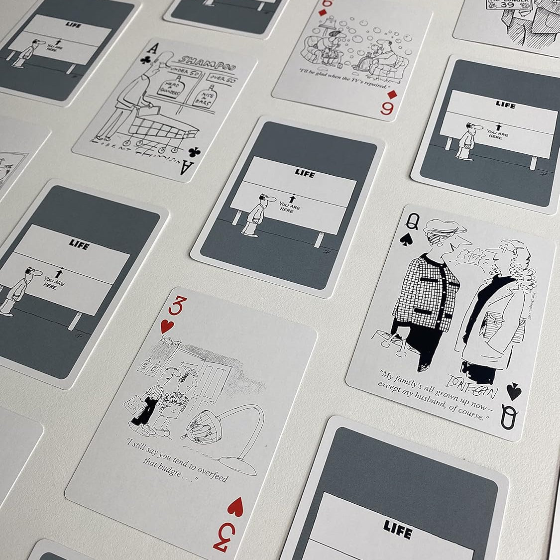 Piatnik Senior Moments deck showing black-and-white cartoons and custom gray card backs