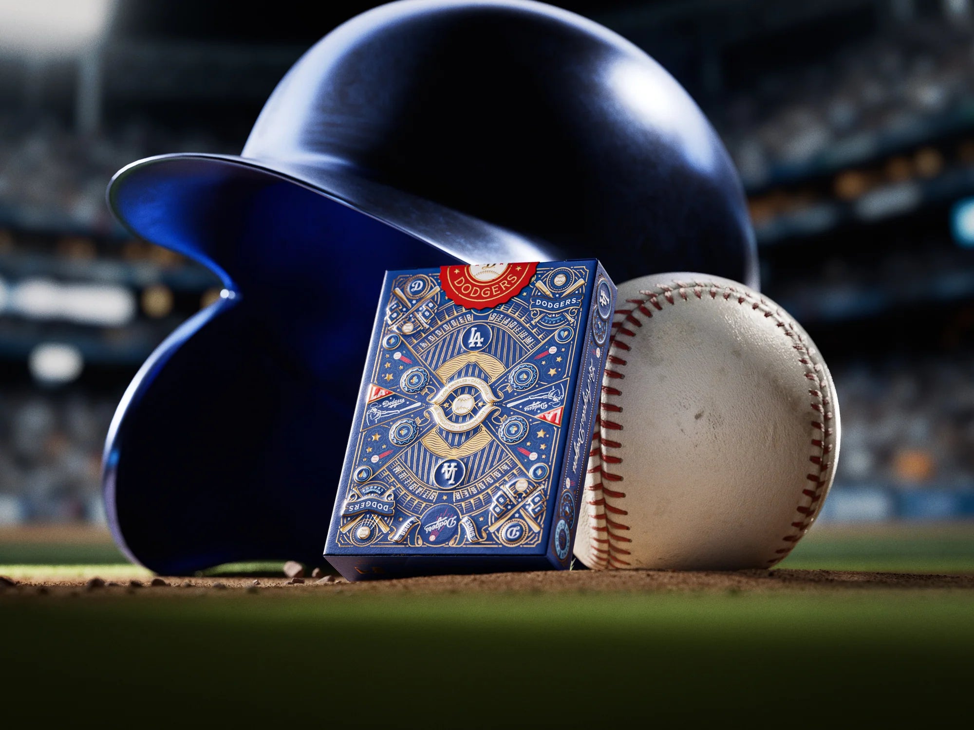 Dodgers tuck box leaning against a baseball helmet and ball on the pitcher’s mound under stadium lights.