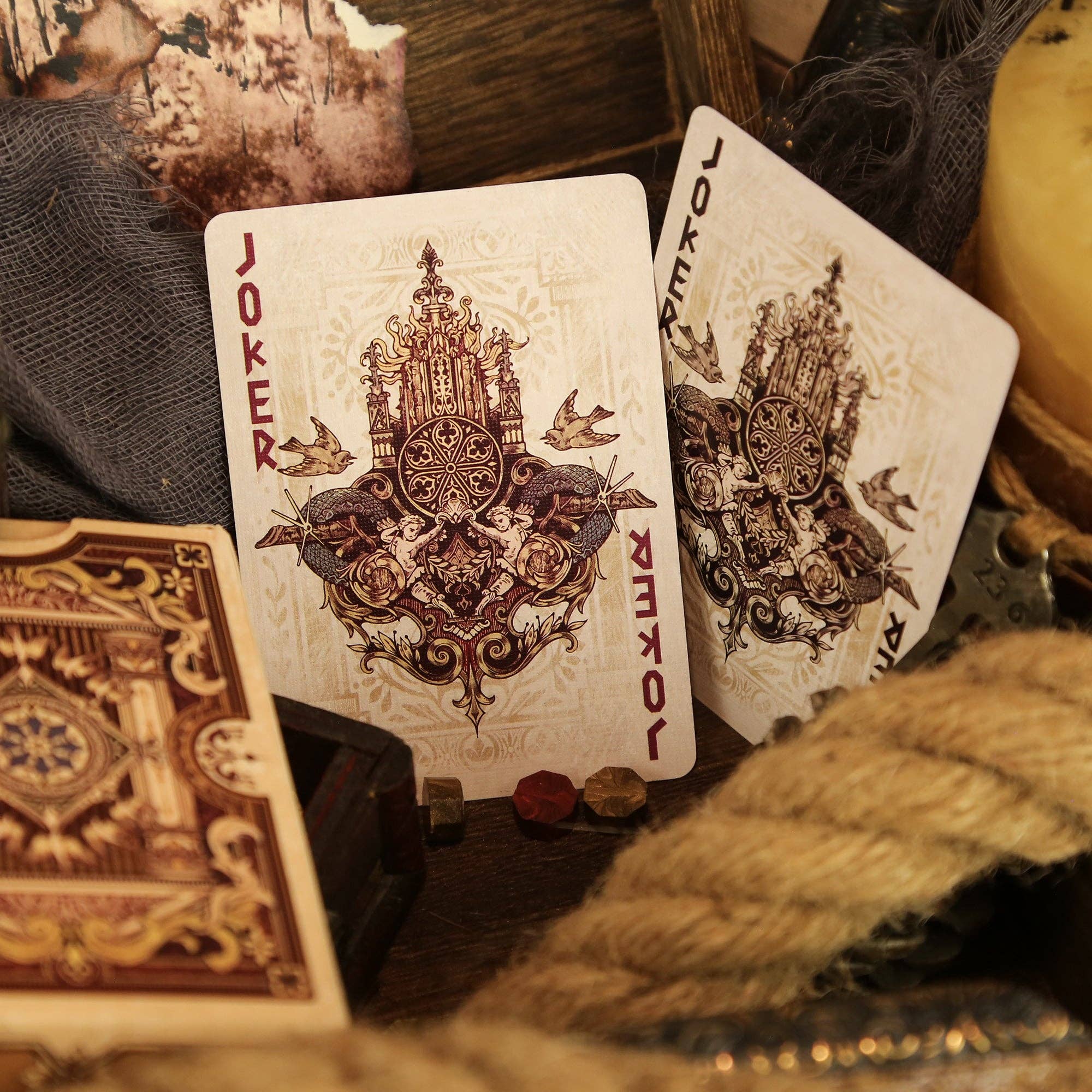 Decorative playing cards with intricate designs and text on a rustic background