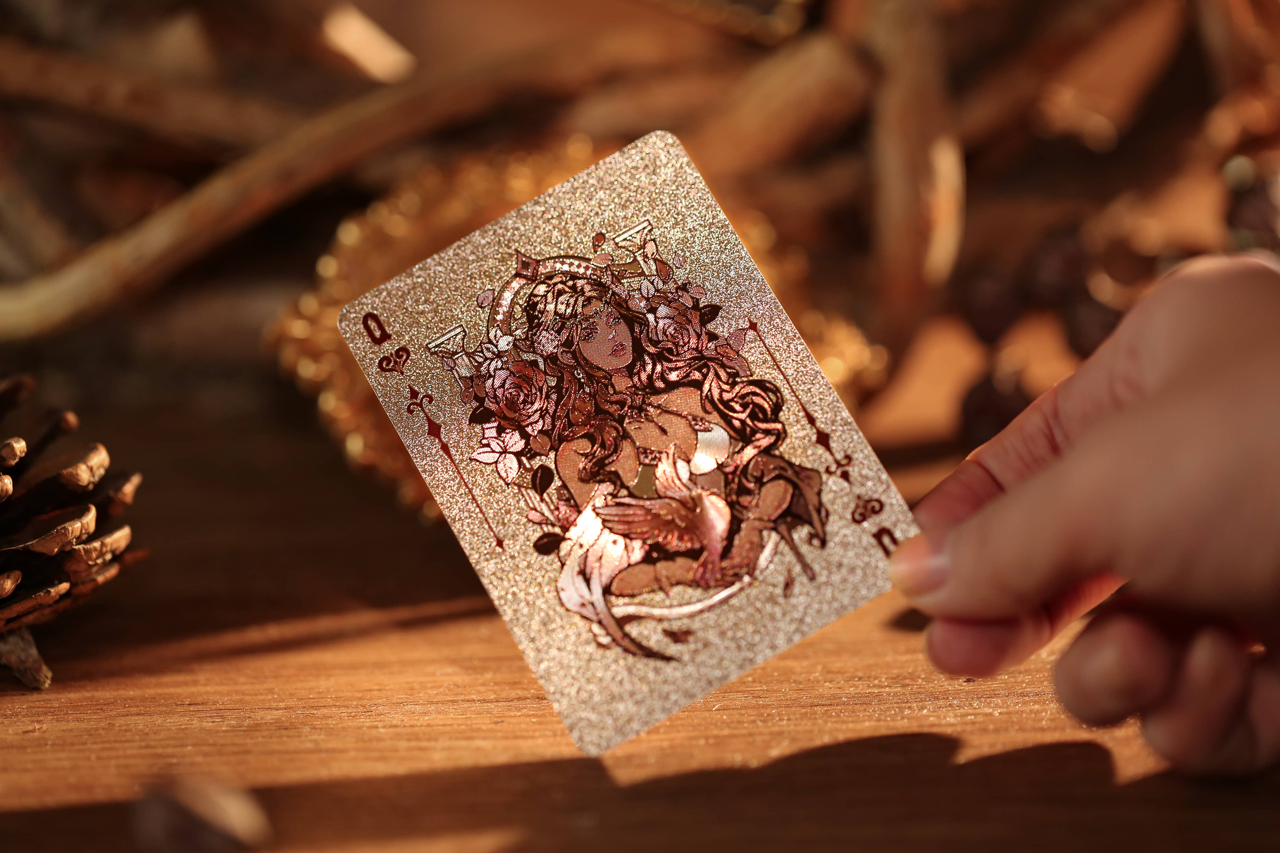 Hand holding a tarot card with intricate designs on a wooden surface