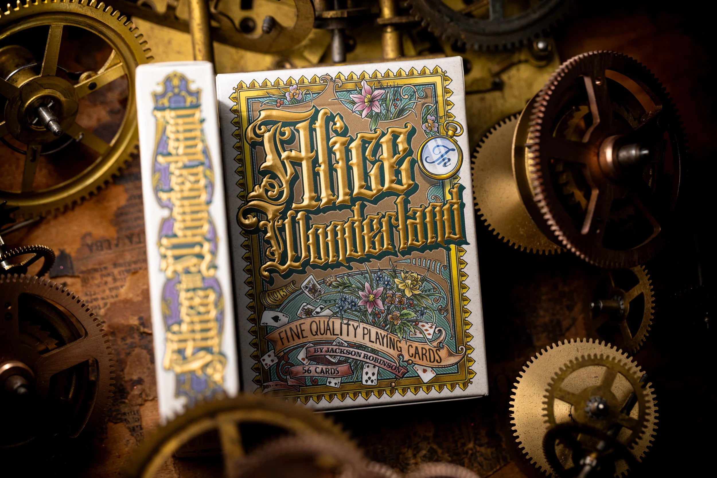 Playing card box with 'Alice in Wonderland' design on a background of mechanical gears.