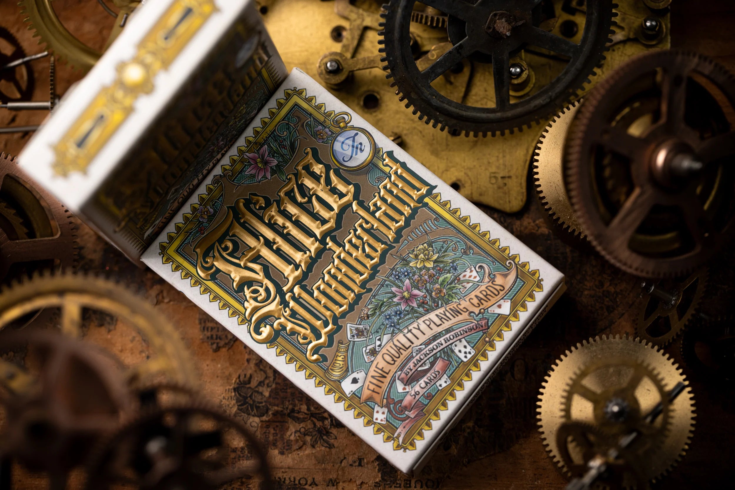 Playing card box with intricate design on a background of mechanical gears