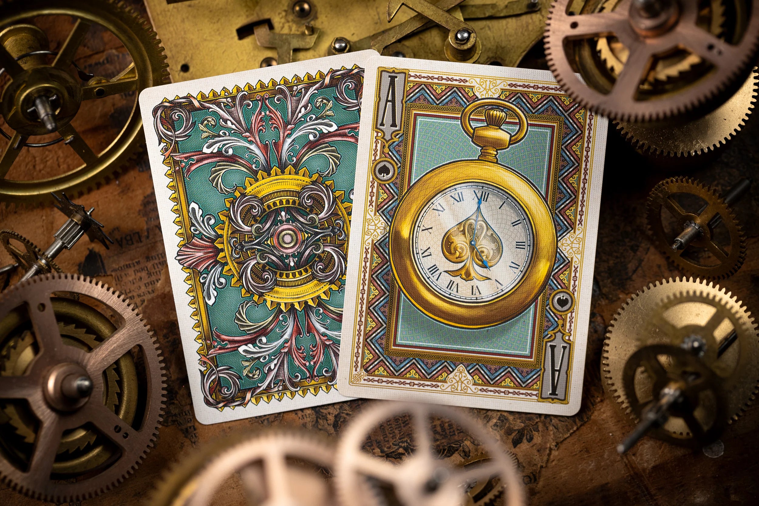 Two playing cards with intricate designs on a background of mechanical gears