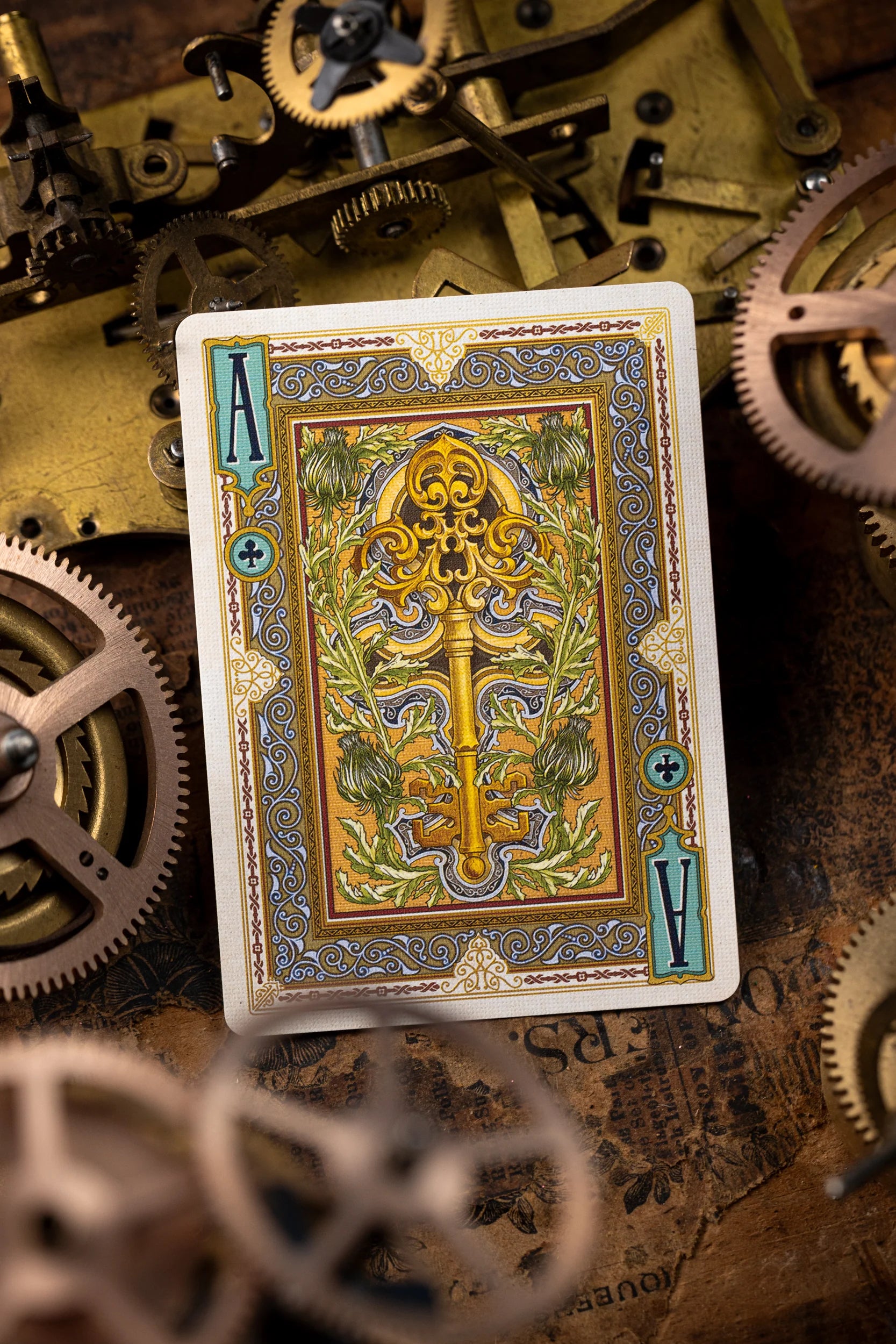 Playing card with decorative design on a background of mechanical gears