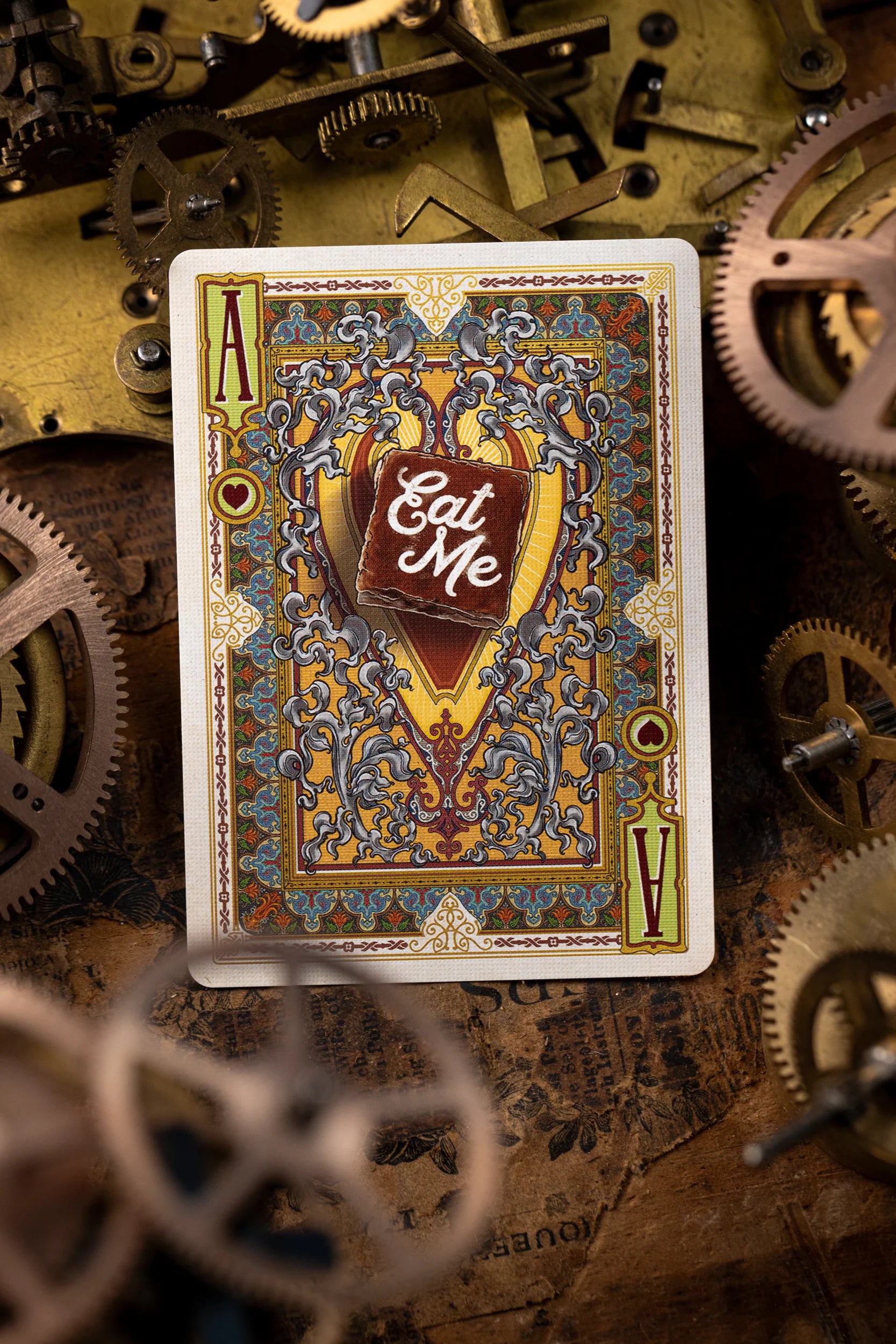 Playing card with 'Eat Me' label on a mechanical background