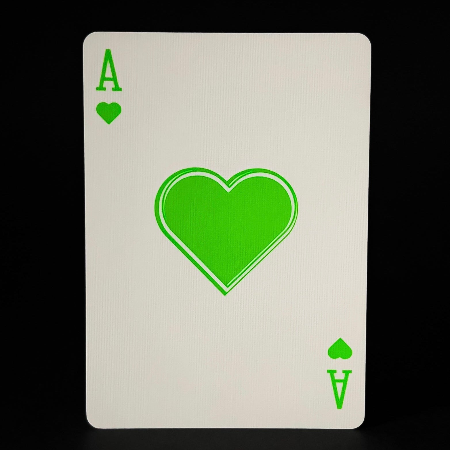 Descendents Playing Card with green heart symbol on a black background