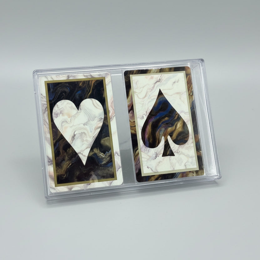 Two Congress playing cards in protective packaging on a wooden surface