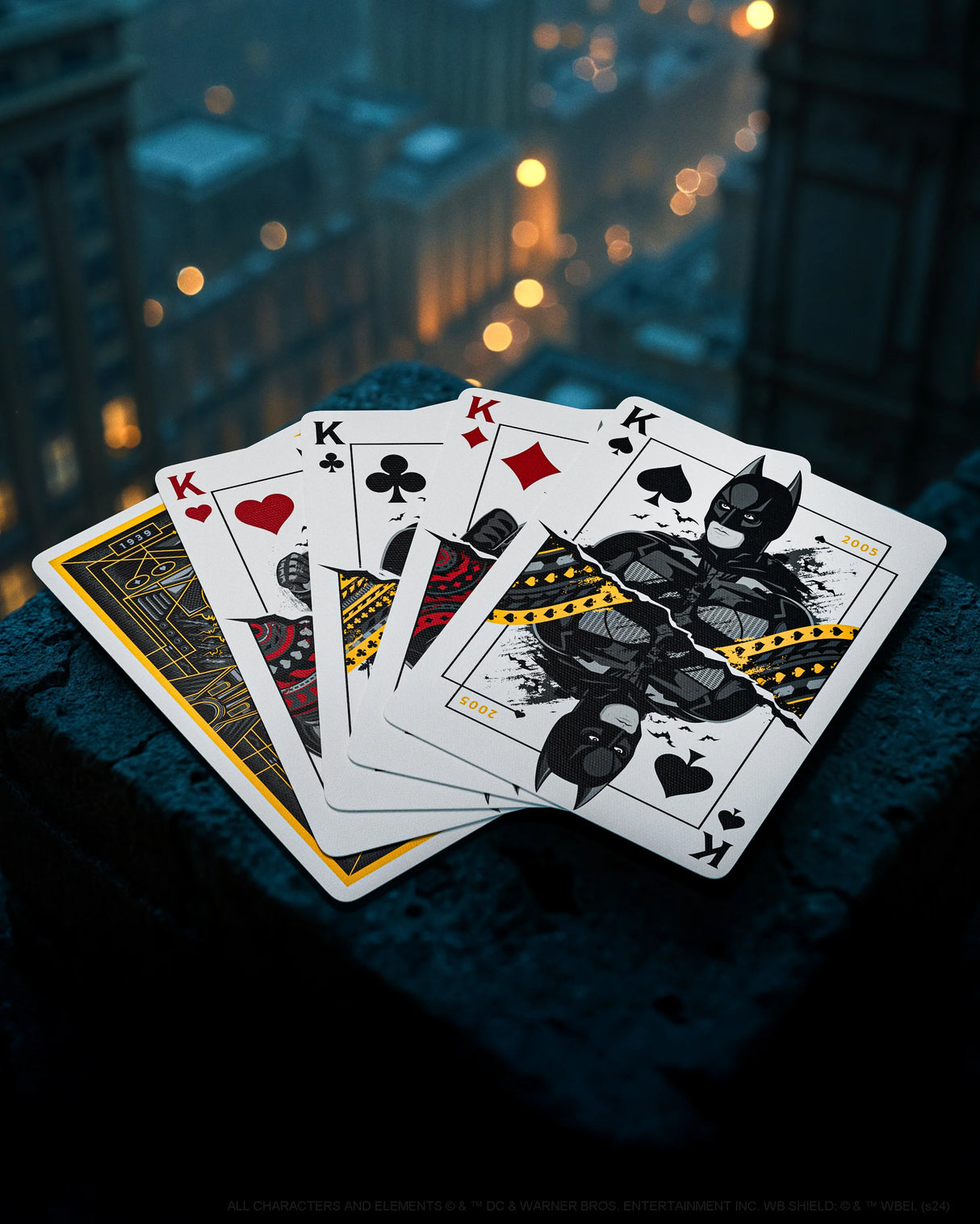 Playing cards with Batman design on a dark surface with cityscape background
