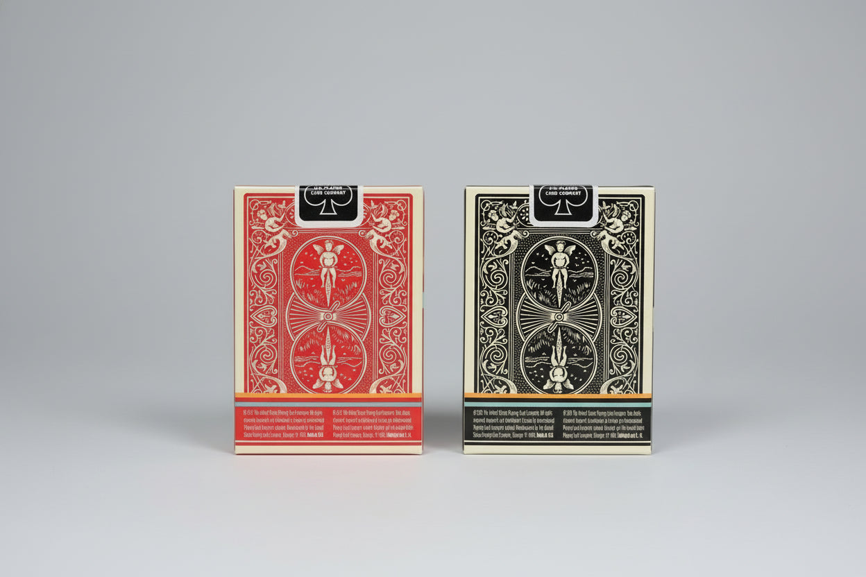 Two packs of United States Playing Card Company playing cards, one red and one gray, with intricate designs.