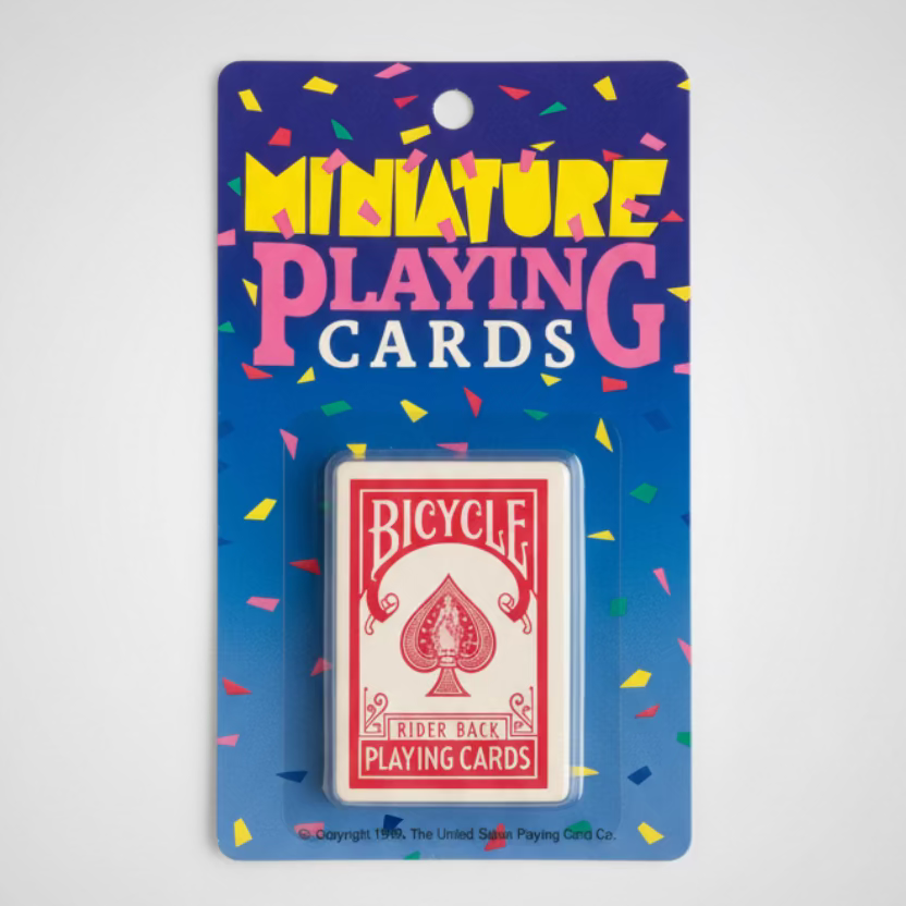 Bicycle miniature playing cards in their original blue and purple cardboard packaging from 1990, displayed on a green felt surface.