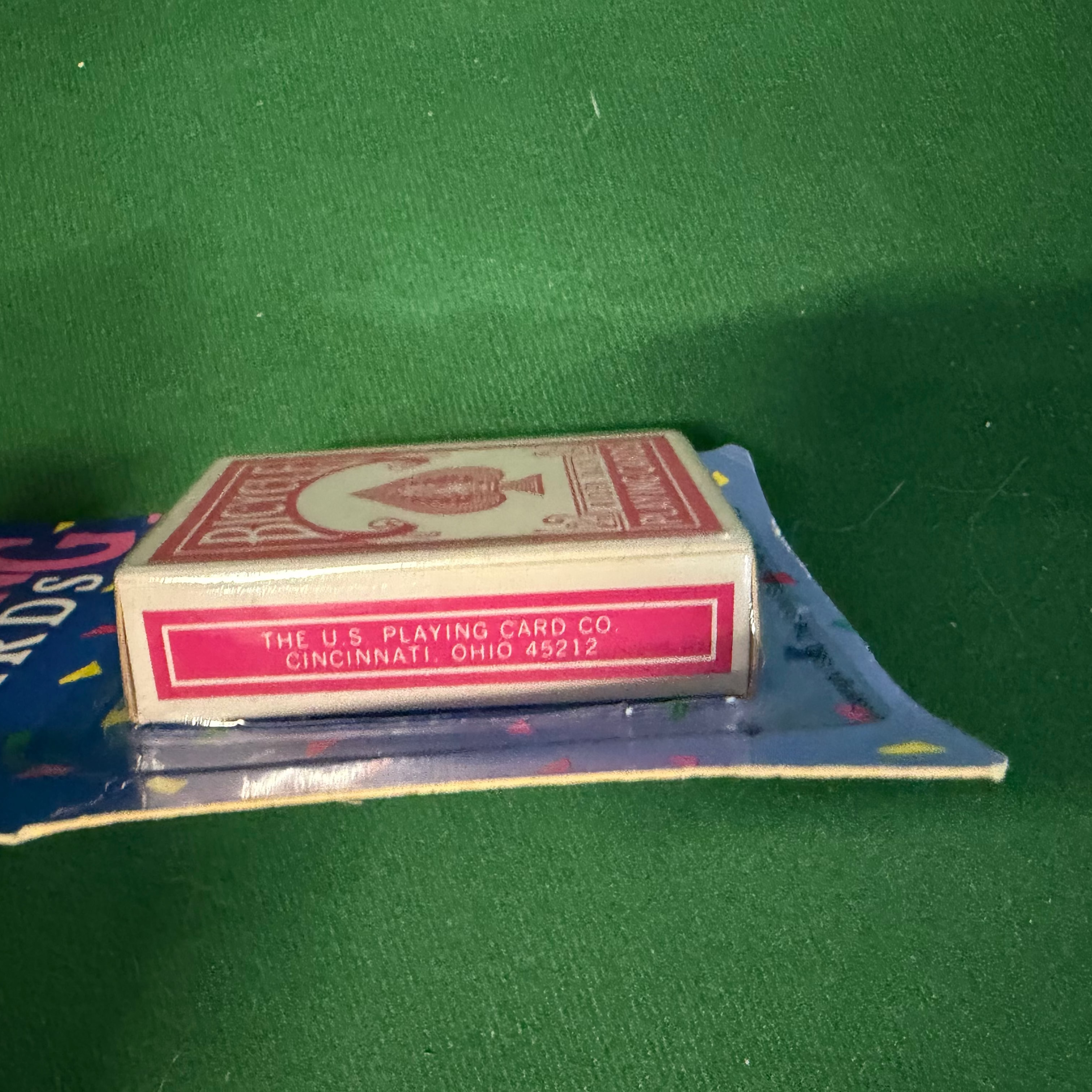 A vintage deck of playing cards in its original blue cardboard packaging, featuring a red and white card box with the U.S.