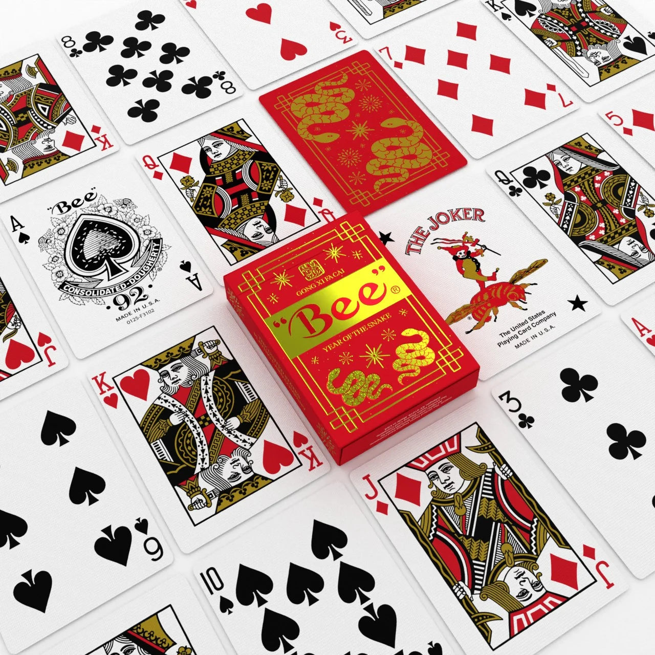 Bee Year of the Snake Playing Cards flat lay with red and gold tuck box, snake back design, Ace of Spades, Joker, and courts