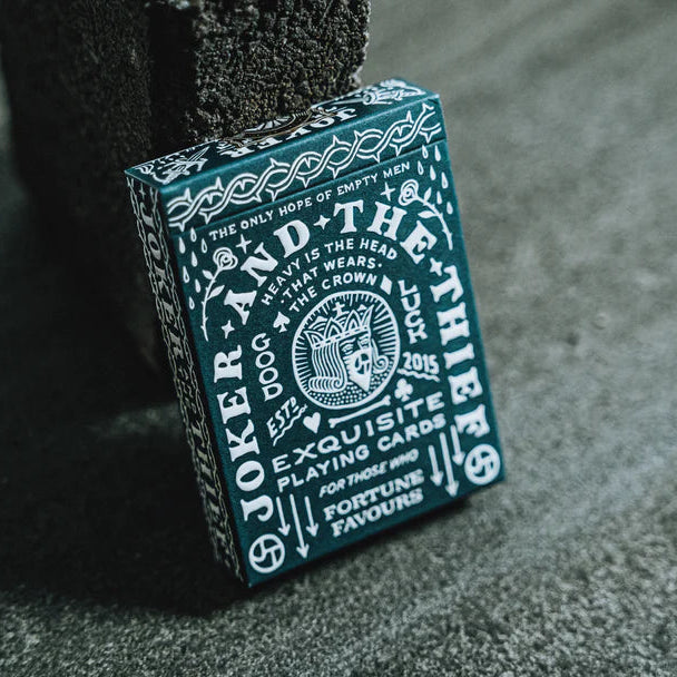 Joker and the Thief Crown playing card box on a textured surface